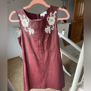 Faux leather mini dress with detailed flowers on collar